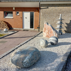 Aménagement extérieur avec graviers décoratifs et pierres ornementales devant une habitation