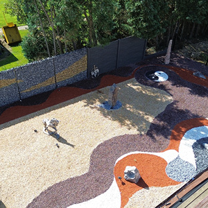 Aménagement de jardin contemporain avec allées minérales, gravier décoratif et clôture béton