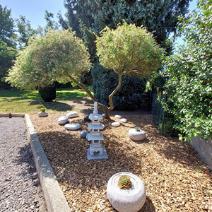 Aménagement de jardin zen avec pas japonais, paillage bois et statue décorative