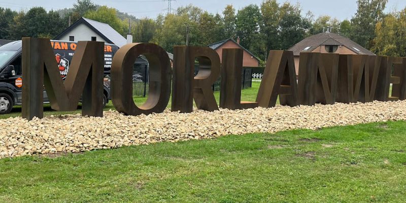 Installation de lettres monumentales en acier à l’entrée de la ville de Morlanwelz, aménagement paysager avec graviers décoratifs